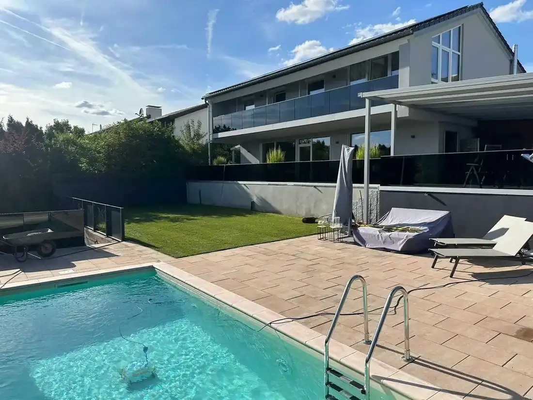 Gepflegter Rasen und Poolbereich an einem Wohnhaus